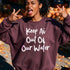 Woman wearing a burgundy sweatshirt with white text that says "Keep Ai Out Of Our Water."