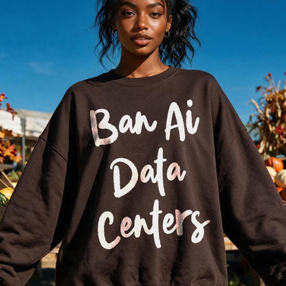 Woman wearing brown sweatshirt with &amp;quot;Ban Ai Data Centers&amp;quot; text, outdoors with pumpkins.