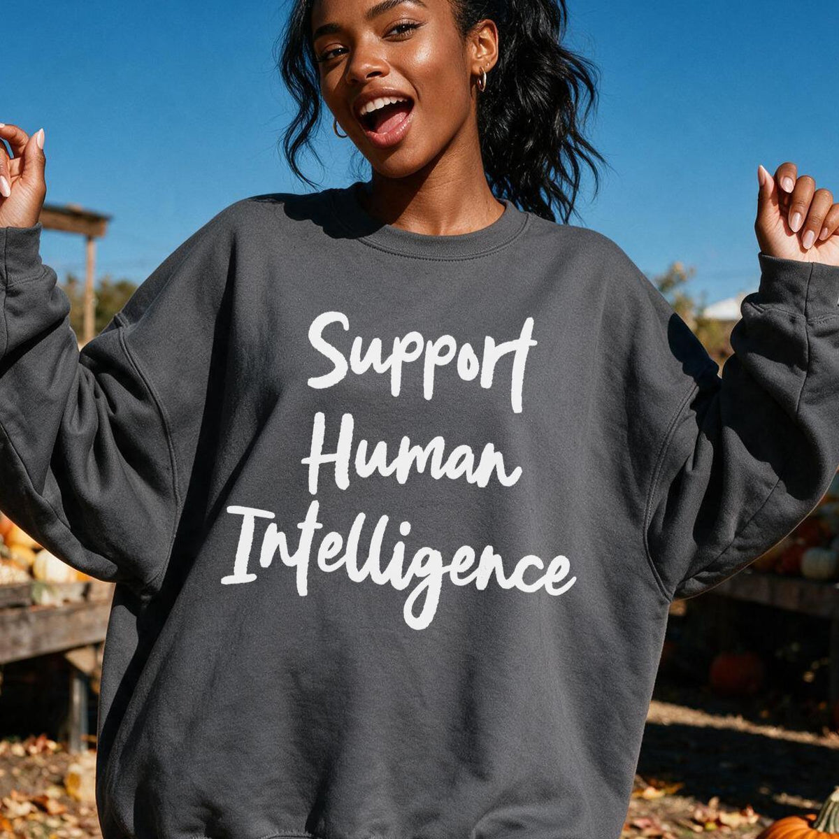 Woman wearing dark grey sweatshirt with white text &amp;quot;Support Human Intelligence&amp;quot;.