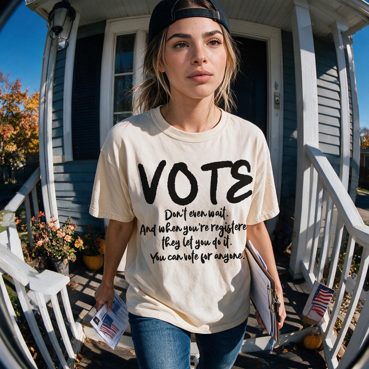 Woman in VOTE shirt stands on porch with election materials.