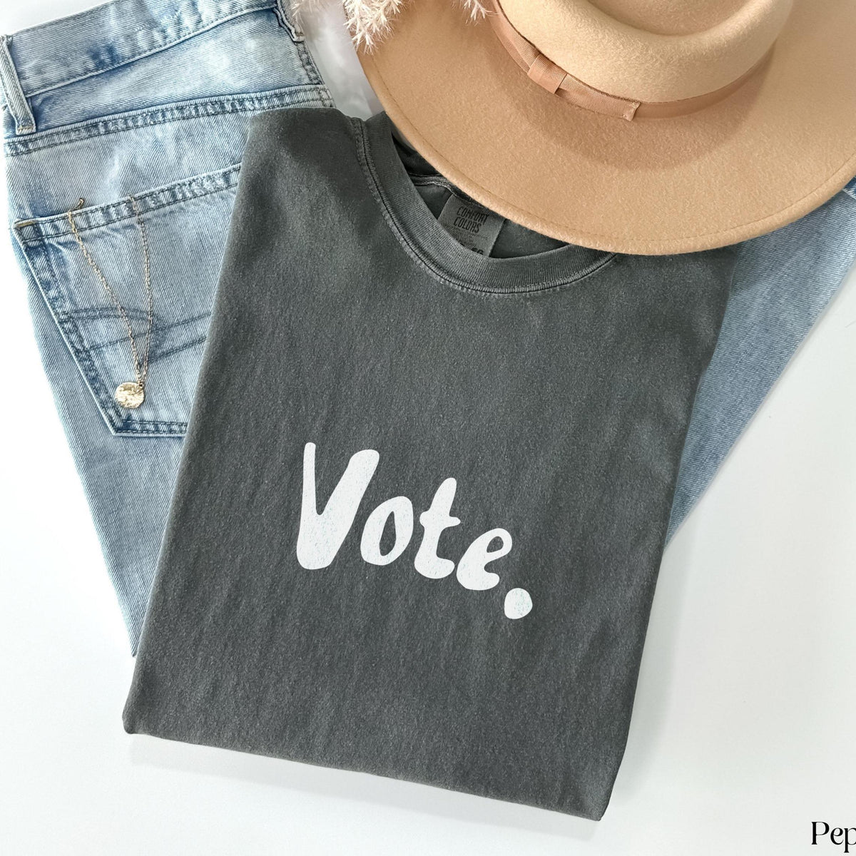 Dark grey t-shirt with white &amp;quot;Vote.&amp;quot; text, light wash jeans, and tan hat.