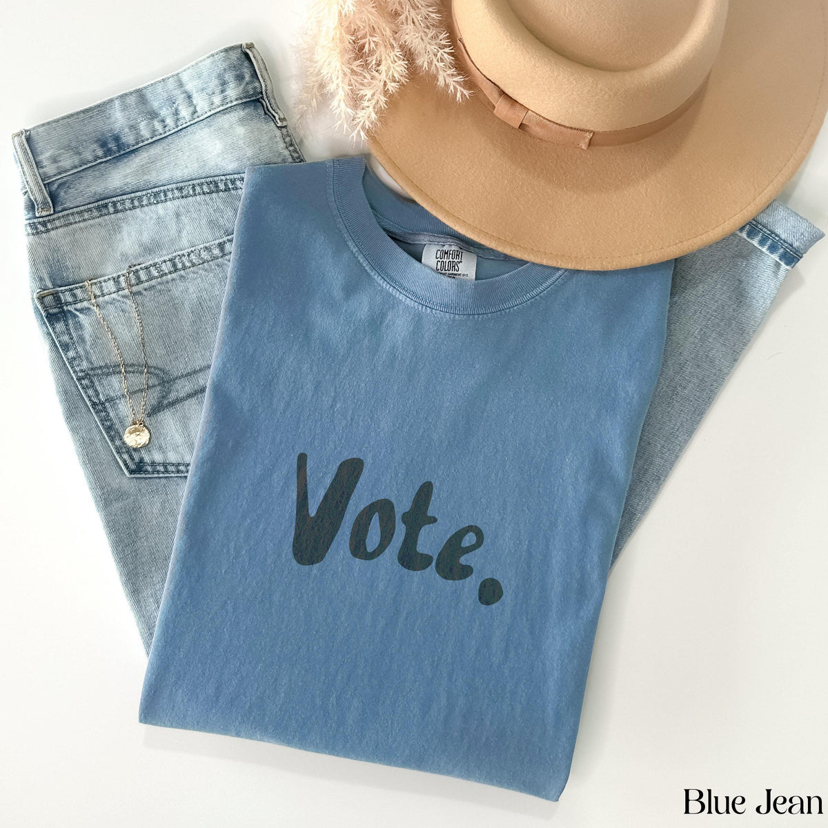 Blue t-shirt with &amp;quot;Vote.&amp;quot; text, jeans, hat, and necklace.