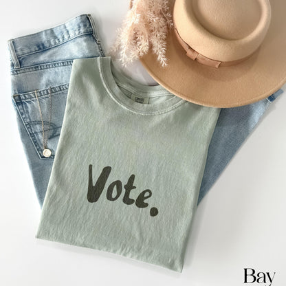 Light green t-shirt with &amp;quot;Vote.&amp;quot; text, jeans, hat, and necklace.