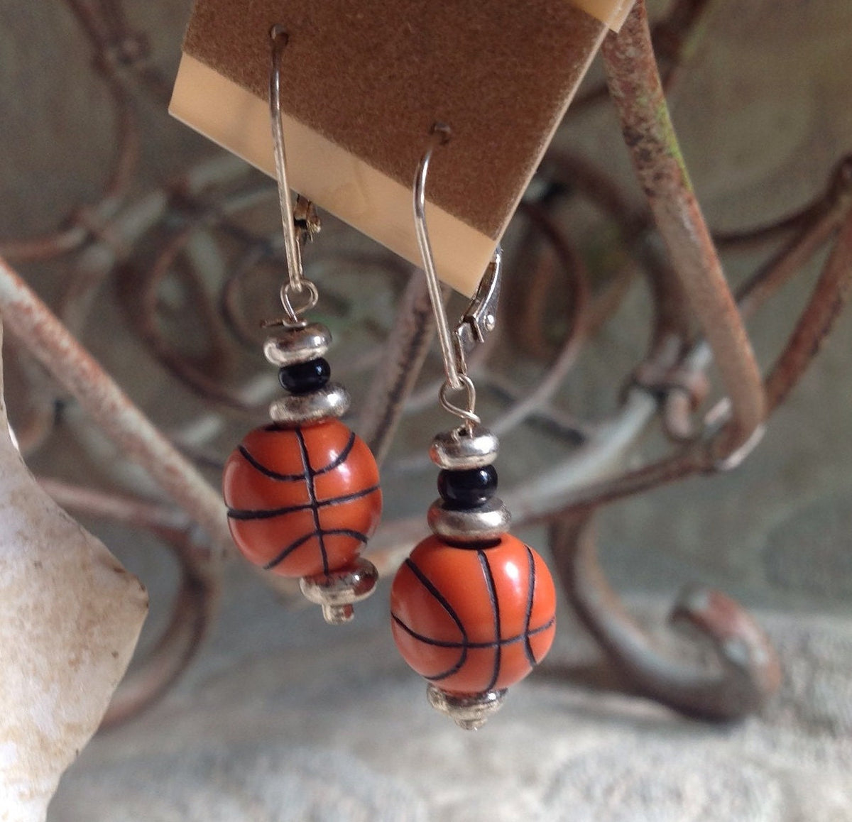 Close-up of teen drop sport ball earrings, ideal gift for a coach or team, reflecting passion for basketball.