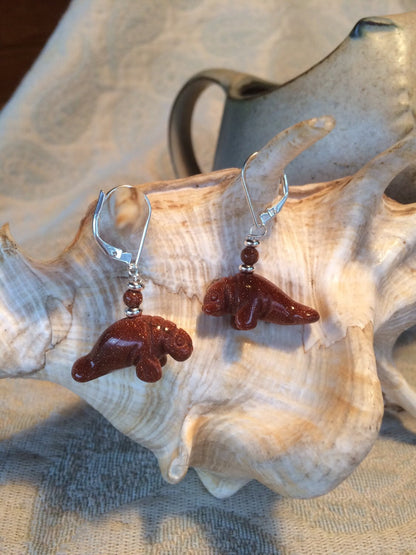 Two pairs of Manatee Earrings featuring different goldstone colors, a thoughtful gift for beach and ocean lovers.
