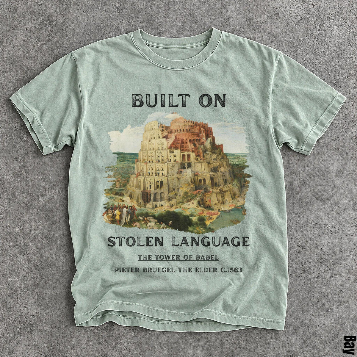 Light green t-shirt with &amp;quot;Built On Stolen Language&amp;quot; and The Tower of Babel artwork.
