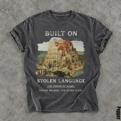 Dark gray t-shirt with Tower of Babel artwork and text &amp;quot;Built on Stolen Language.&amp;quot;
