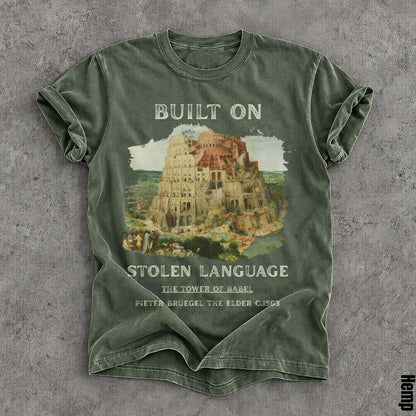 Green t-shirt with &amp;quot;BUILT ON STOLEN LANGUAGE&amp;quot; and Tower of Babel artwork.