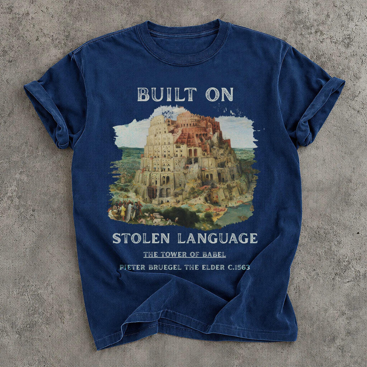 Blue t-shirt with artwork of Tower of Babel and text &amp;quot;BUILT ON STOLEN LANGUAGE&amp;quot;.