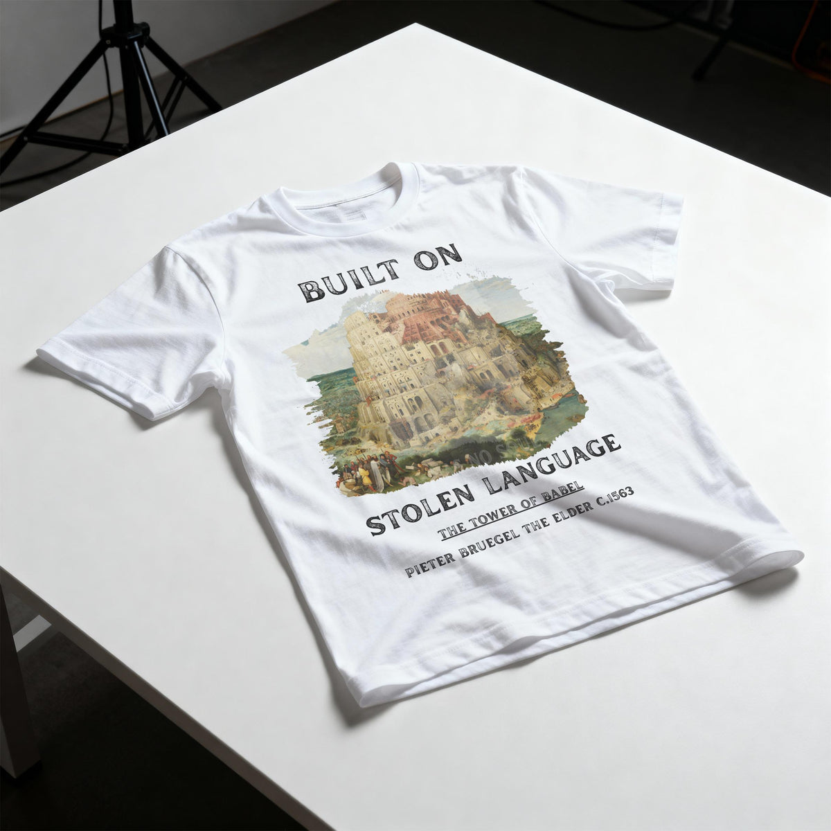 White t-shirt with &amp;quot;Built On Stolen Language&amp;quot; and Tower of Babel graphic.