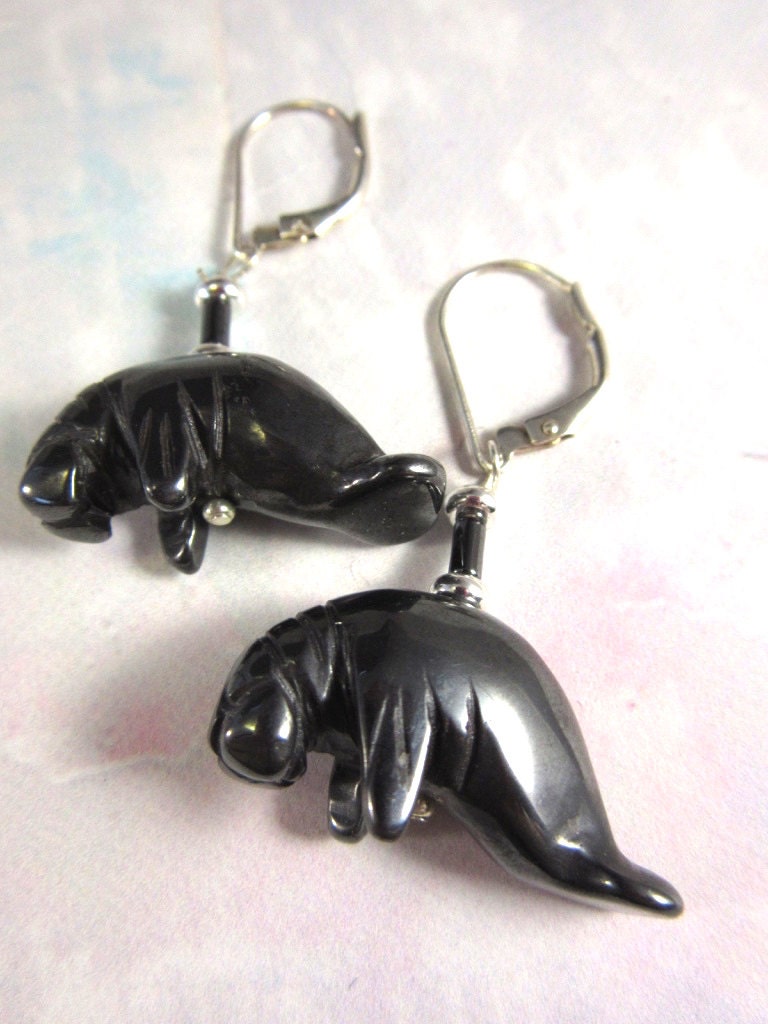 Manatee Earrings displayed on a table, showcasing the beautiful artisan craftsmanship of hematite jewelry.