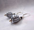 Handmade Volleyball Earrings featuring oval beads with black and white stripes, sterling silver lever backs, and sporty style—perfect for fans of unique sport jewelry. Displayed on a light background.