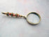 Golden Orange Bead Magnify Glass - A luxurious magnifier with a beaded sunburst orange handle and golden faceted glass, perfect as a unique gift for grandparents or moms.