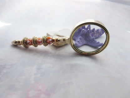 Close-up of Golden Orange Bead Magnify Glass revealing detailed craftsmanship with orange beads and gold metal, ideal for art viewing and small details.