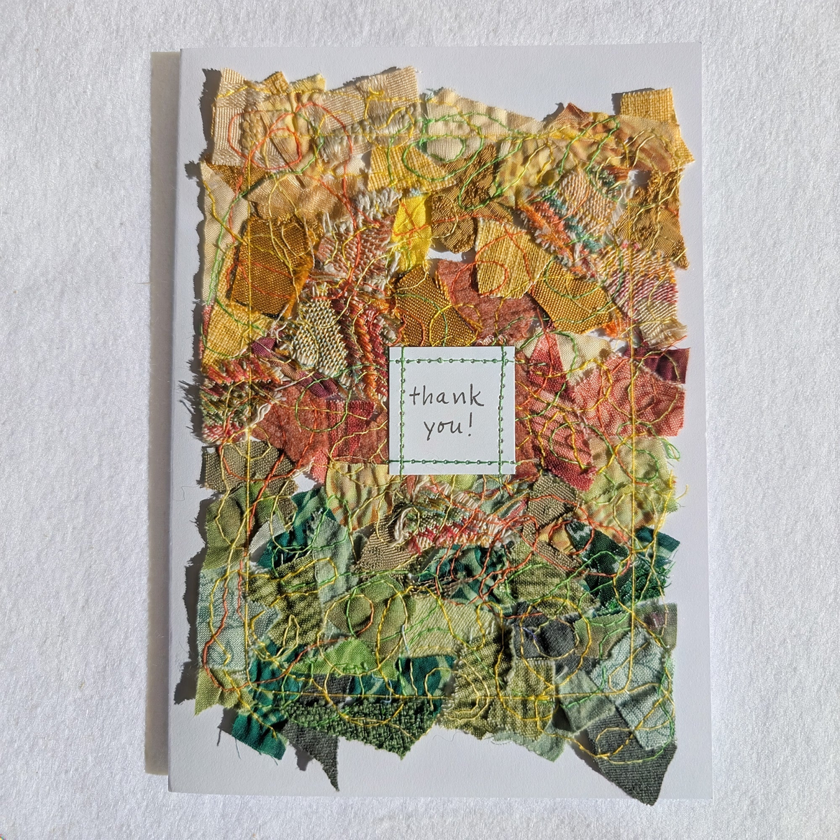 Five by seven inch blank card with yellow, orange and green fabric collage; the words, thank you, hand lettered