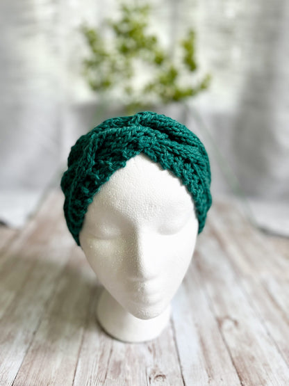 A mannequin head displays a green hand-dyed, Virginia-raised merino cabled ear warmer