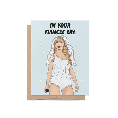 Engagement card with the phrase “In Your Fiancée Era” featuring an illustration of a woman in a sparkling outfit with a bridal veil and microphone.