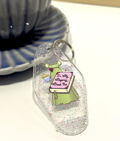 Inspired by the romance of the Regency Era, this whimsical hand drawn empire dress is paired with trinkets of the time including a cute teacup, tiara and fan! 📖 ☕ ✨👑 Perfect motel keychain for any bookish babe. Pair it with the matching sticker!