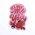 A pink sticker with the text &