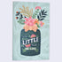 A flat lay notebook with a colorful cover featuring a botanical design and a textual phrase &