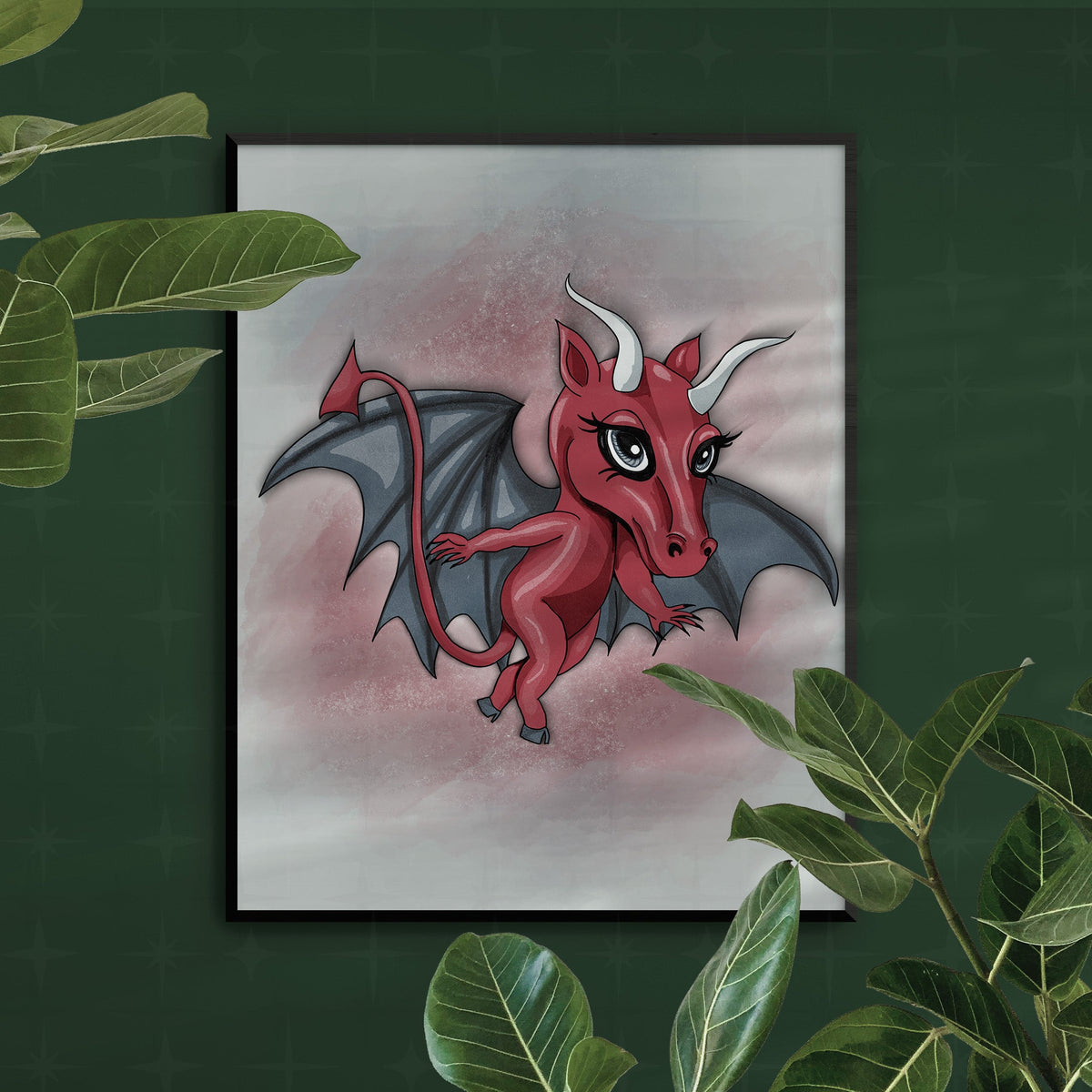 Chibi cryptid art print in a slim black frame on a dark green wall, framed by trailing green houseplant leaves.