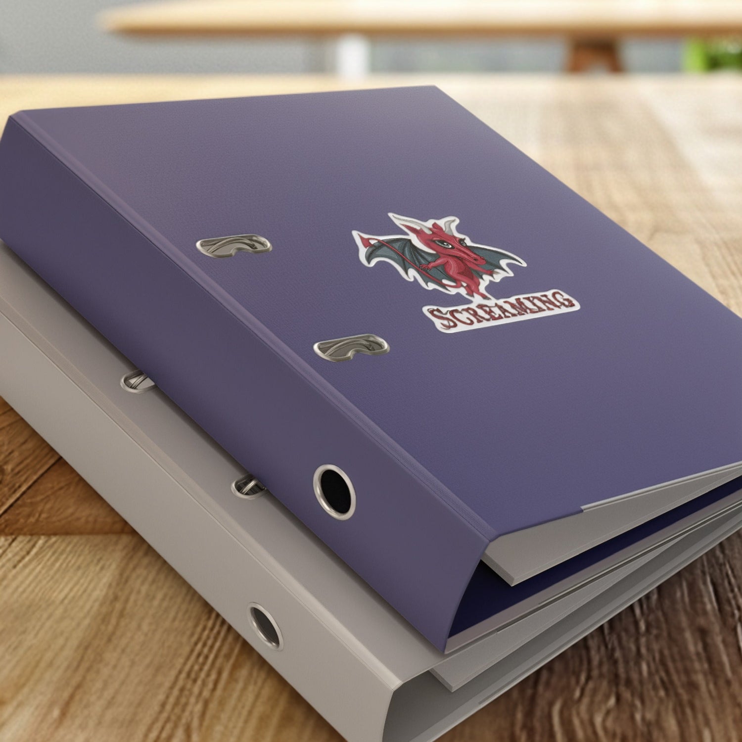 Jersey Devil cryptid sticker on a purple binder resting on a stack of binders