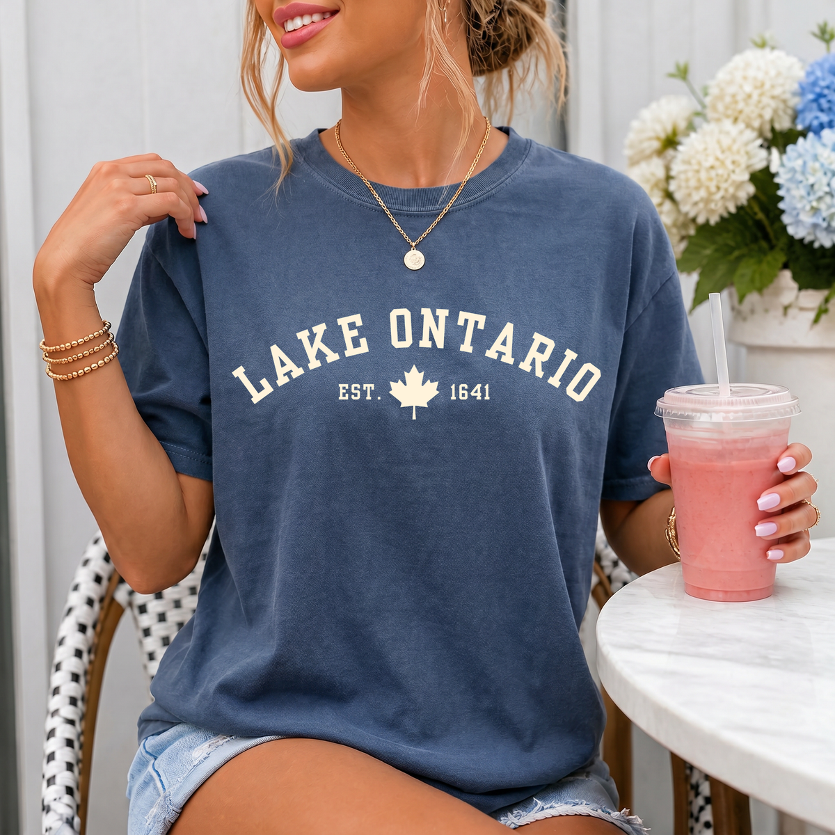 A woman wearing a faded blue crewneck t-shirt with &