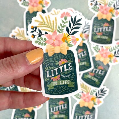 hand holding a sticker of a flower vase with lettering "it&