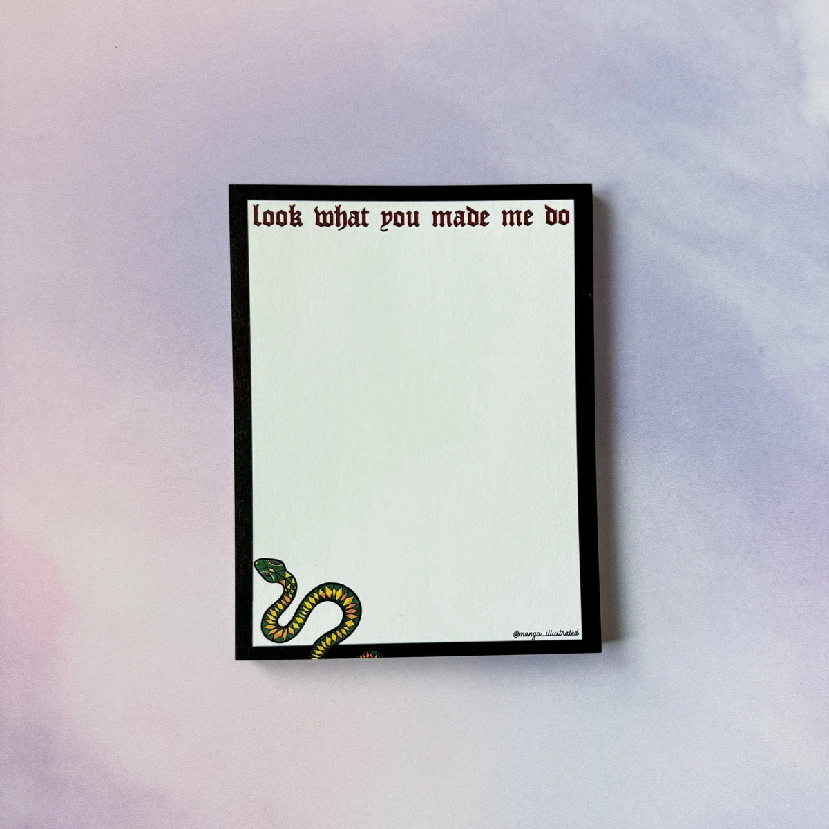 Look What You Made Me Do notepad flat lay — black bordered desk notepad with snake illustration by indie artist MangoIllustrated
