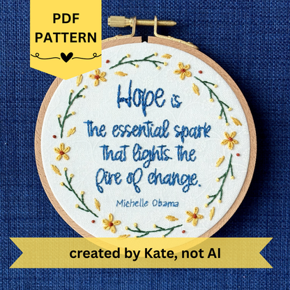 PDF pattern created by Kate, not AI. "Hope is the essential spark that lights the fire of change. Michelle Obama" Quote hand embroidered in dark blue. Text is surrounded by floral wreath of golden yellow sunflowers and dark green stems with light yellow buds. Fabric is white-on-white cotton. Displayed as wall art in a light wooden embroidery hoop.