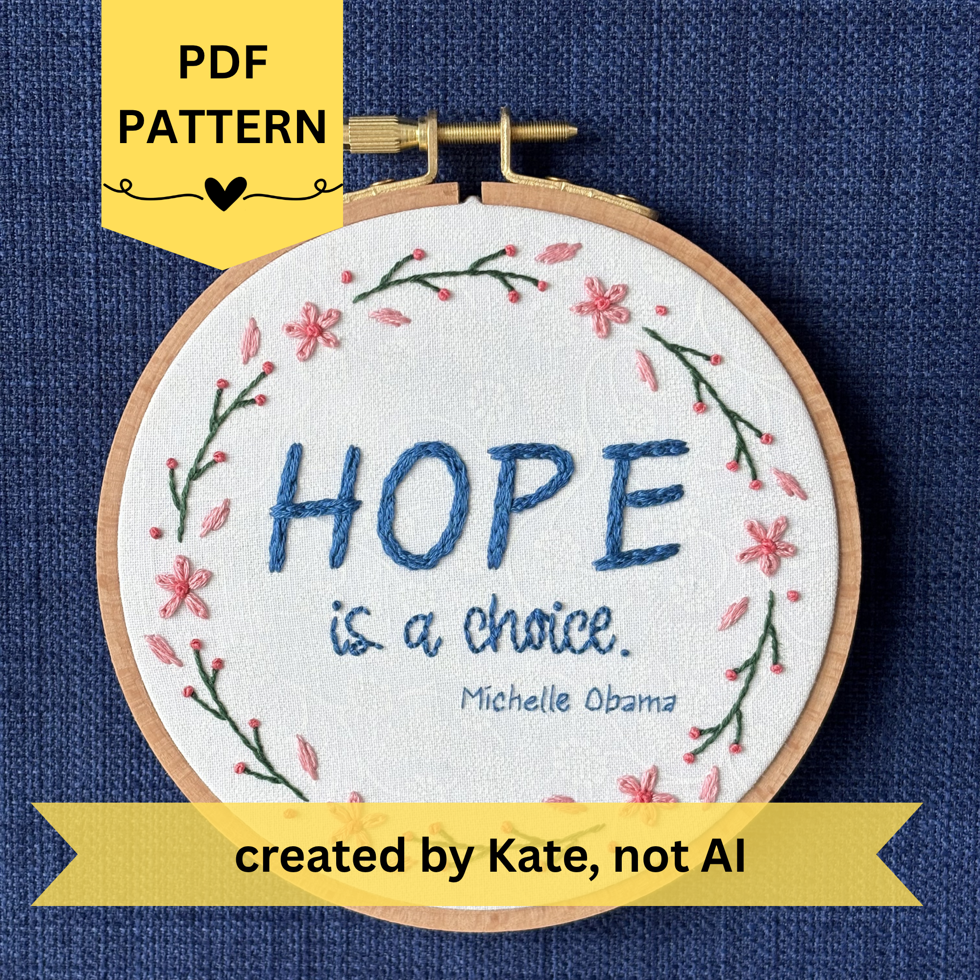PDF pattern created by Kate, not AI. "Hope is a choice. Michelle Obama" Quote hand embroidered in dark blue. Text is surrounded by floral wreath of pink cherry blossom flowers and stems with buds. Fabric is white-on-white cotton. Displayed as wall art in a light wooden embroidery hoop.