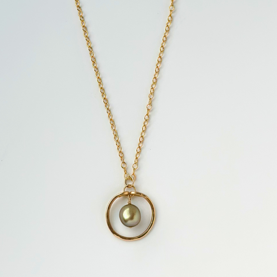 image of gold filled necklace with round pendant featuring a green pearl in the middle