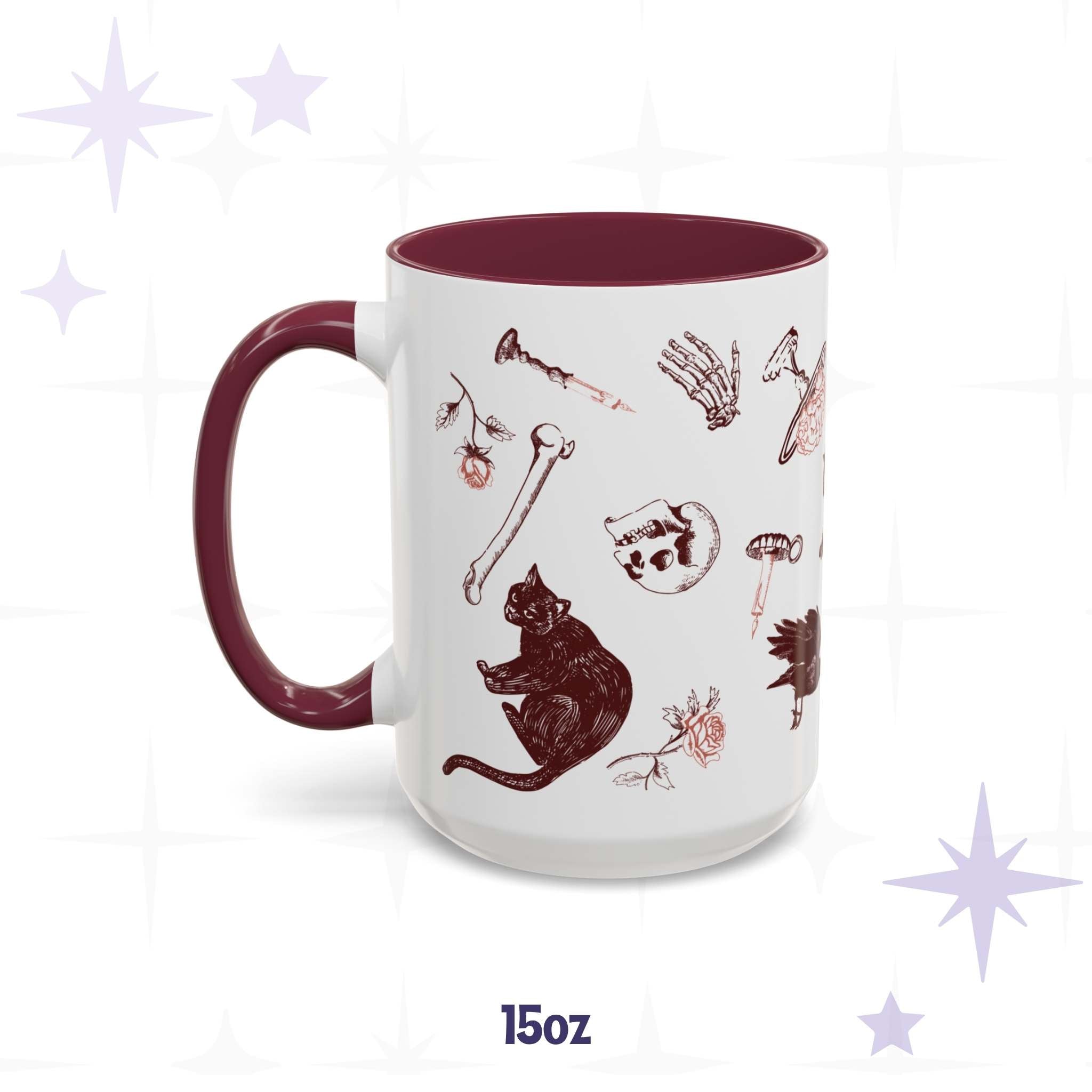 Fifteen-ounce oxblood skull and bones mug on a starred background, red gothic scatter of black cats, a raven, a skull, roses, and a teapot mid-pour, burgundy handle