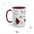 Fifteen-ounce oxblood skull and bones mug on a starred background, red gothic scatter of black cats, a raven, a skull, roses, and a teapot mid-pour, burgundy handle