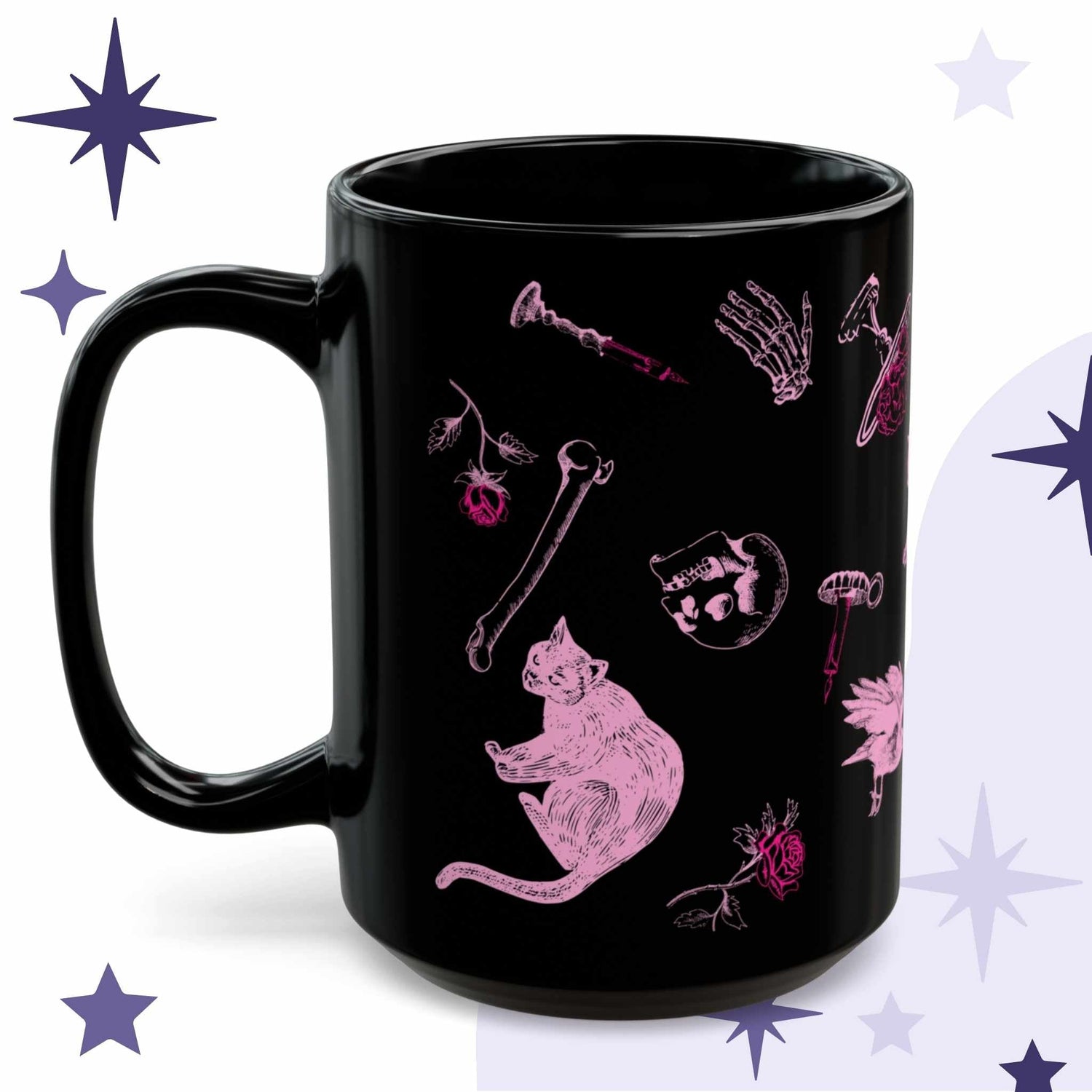 Pastel goth mug in black ceramic with hot pink engraving-style illustration of a black cat, loose bones, a skull, and a rose