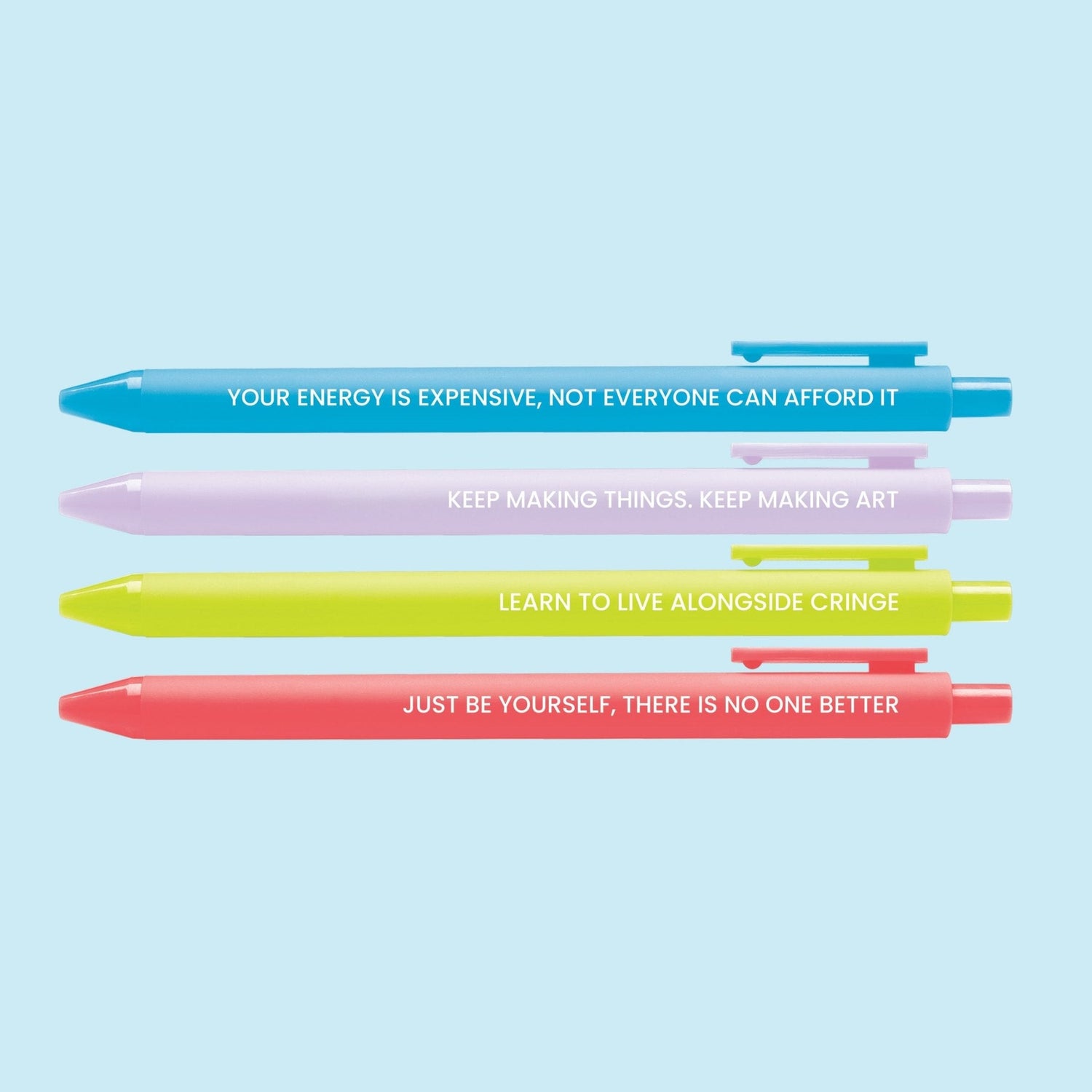 Set of four colorful pens with motivational affirmations, including “Your energy is expensive,” “Keep making art,” “Live alongside cringe,” and “Just be yourself.”