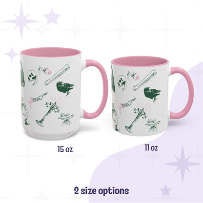Two pink-handled preppy skull and bones mugs in 15oz and 11oz, green and pink macabre scatter print wrapping the ceramic