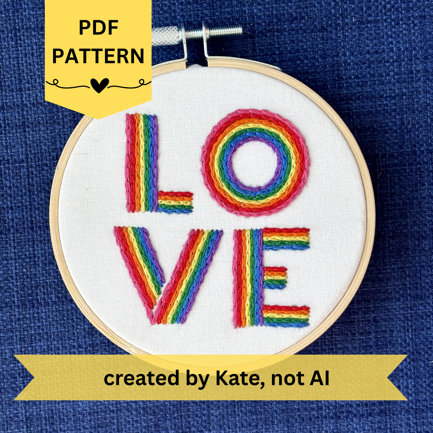 PDF pattern created by Kate, not AI. The word "love" is hand embroidered on two lines, in a square, in all capital letters. Each letter is stitched in stripes of rainbow colors: pink, red, orange, yellow, green, blue, purple. Text is sewn on white cotton. Framed as wall art in light wood embroidery hoop.