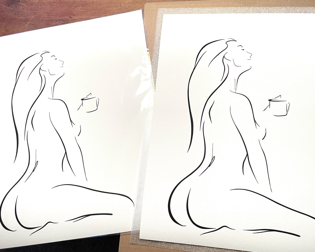 Black and white elegant line art illustration of a sensual woman enjoying her first cup of coffee, head tilted back, in a peaceful pose, titled "But First, Coffee"; black frame on white wainscoting with modern black decor; printed on Aquarelle Rag paper, packaged for shipping.