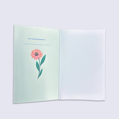 Open notebook with a flower illustration on a light green page.