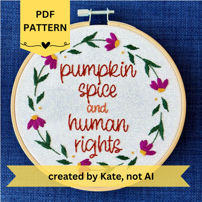 PDF pattern. Created by Kate, not AI. "Pumpkin spice and human rights". Handwriting font text hand embroidered in two shades of medium orange. Surrounded by a floral wreath of bright pink asters with yellow centers and green leaves and stems. Framed in light wood embroidery hoop and displayed as wall art.