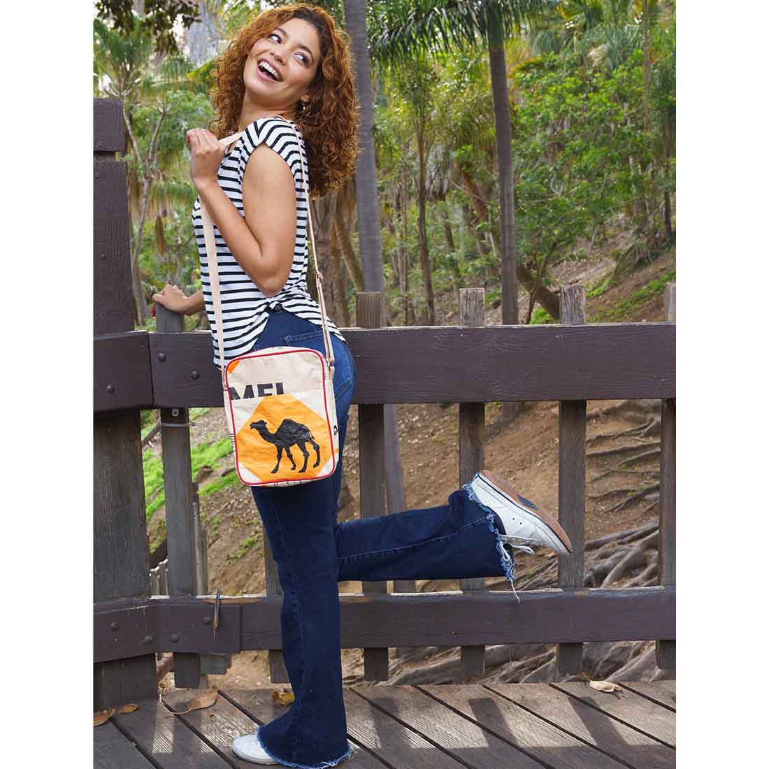 Woman  in the park wearing recycled crossbody purse - camel design