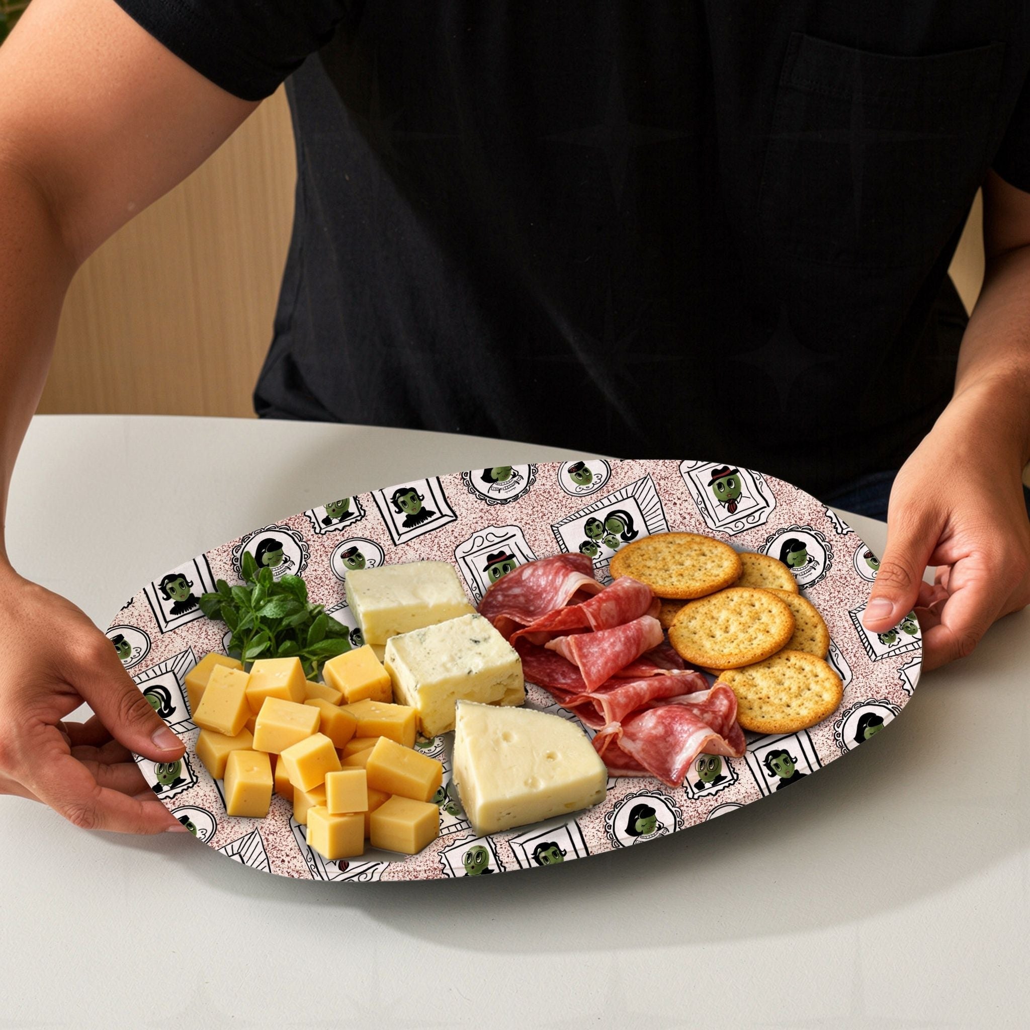 Retro olive portrait serving platter in red speckle colorway loaded with charcuterie board including cheeses, salami, and crackers, mid-century gallery wall pattern visible at edges