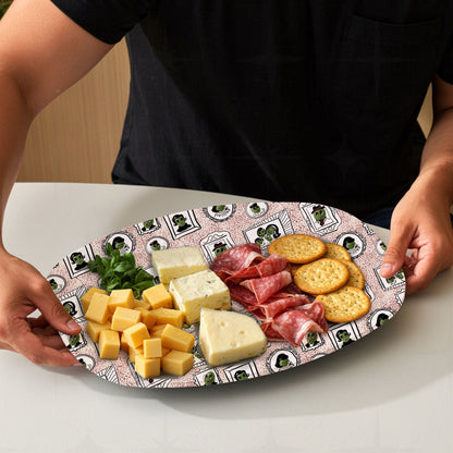 Retro olive portrait serving platter in red speckle colorway loaded with charcuterie board including cheeses, salami, and crackers, mid-century gallery wall pattern visible at edges