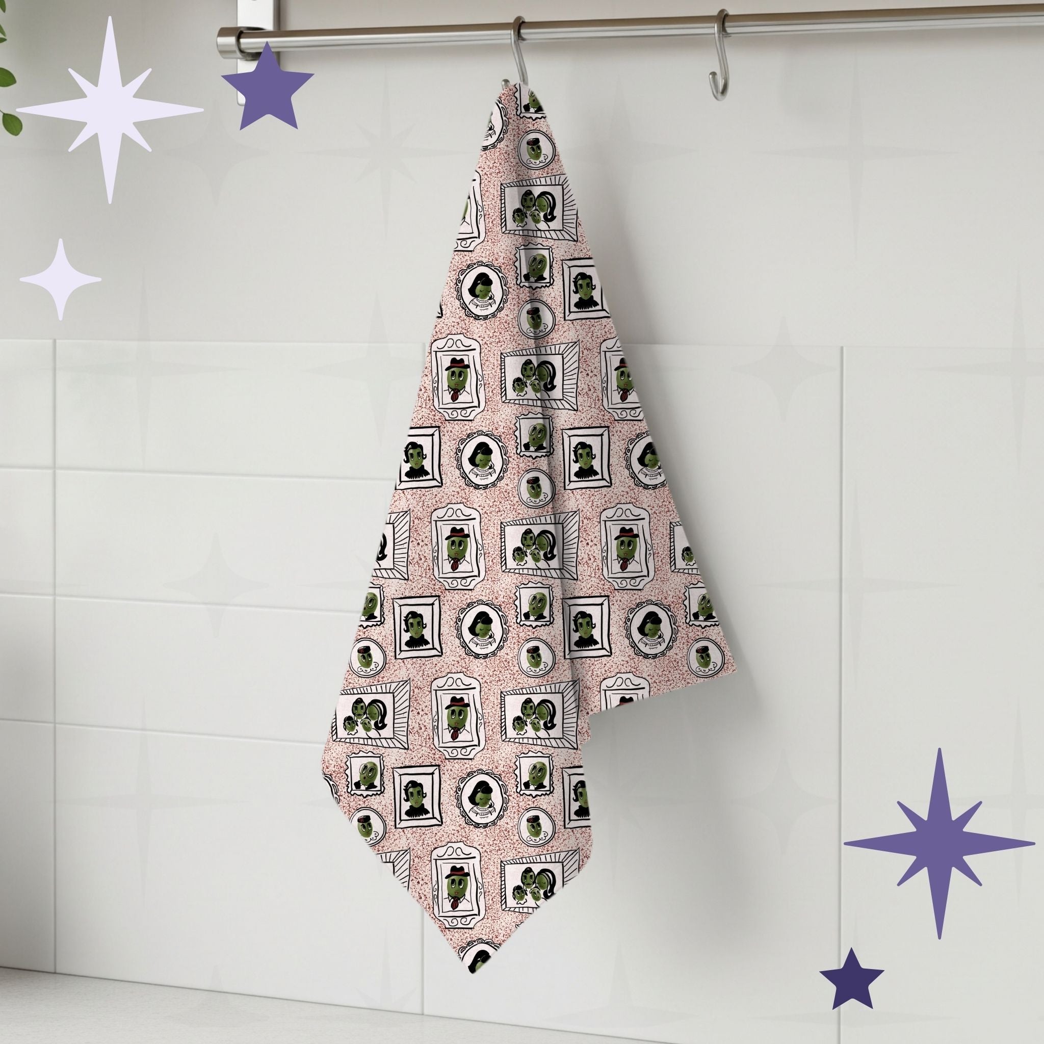 Dusty rose retro olive portrait tea towel hanging from silver kitchen hook against white tile backsplash