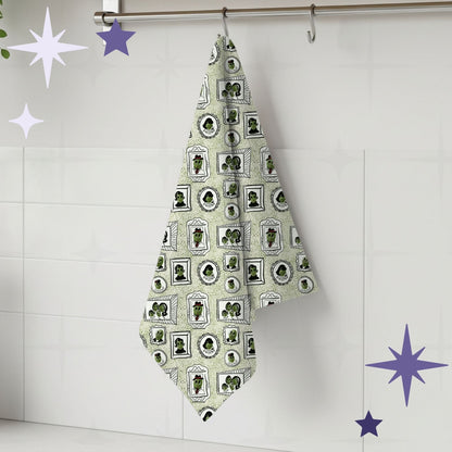 Sage green retro olive portrait tea towel hanging from silver kitchen hook against white tile backsplash