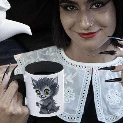 Woman with red lips and black nails holding the cute werewolf coffee mug filled with black coffee