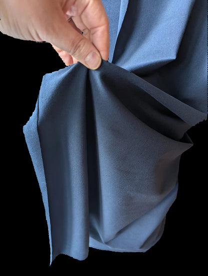 Holding navy cotton spandex fabric to show its structured drape