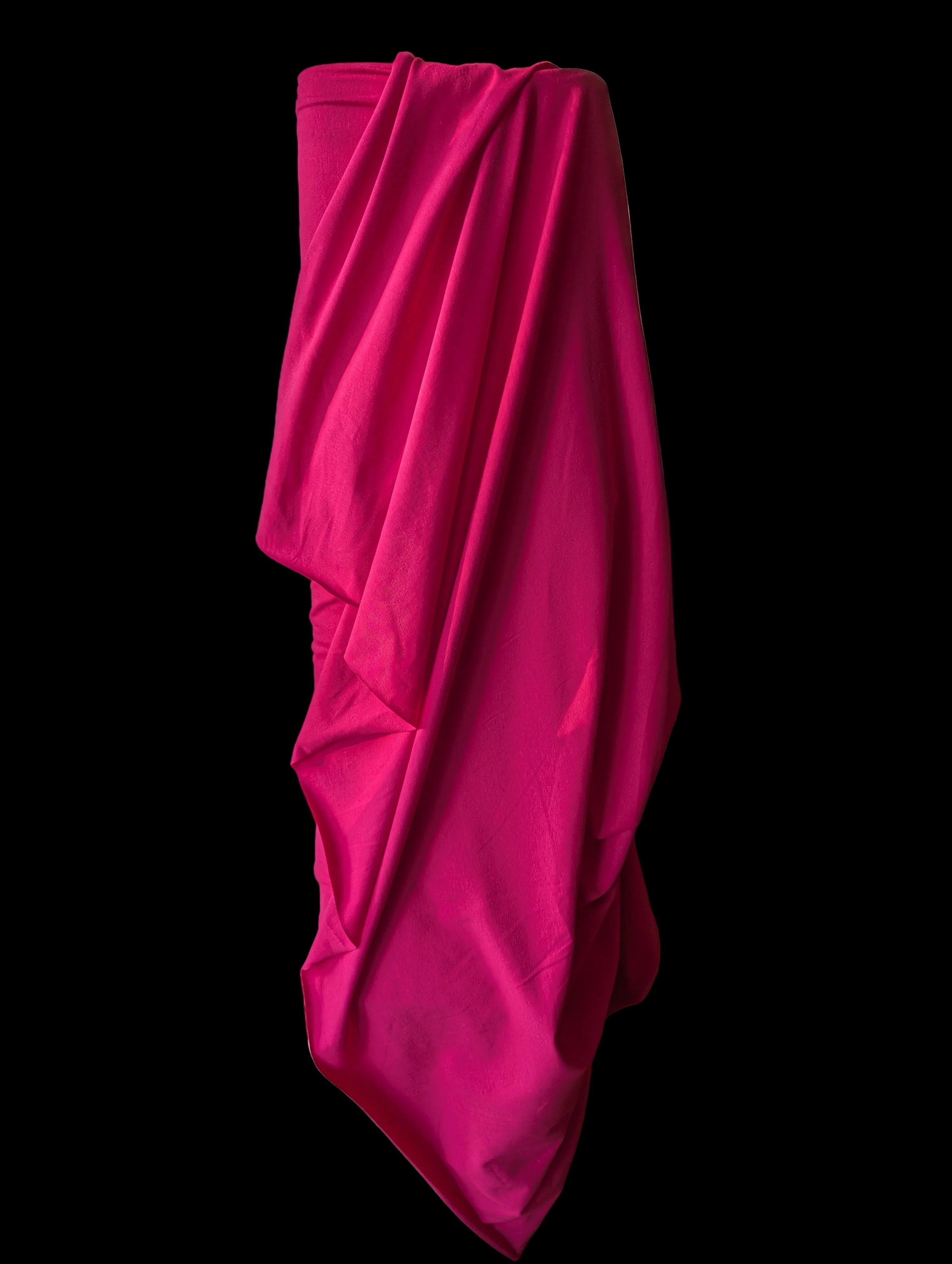 Hot pink cotton spandex knit draped over the bolt