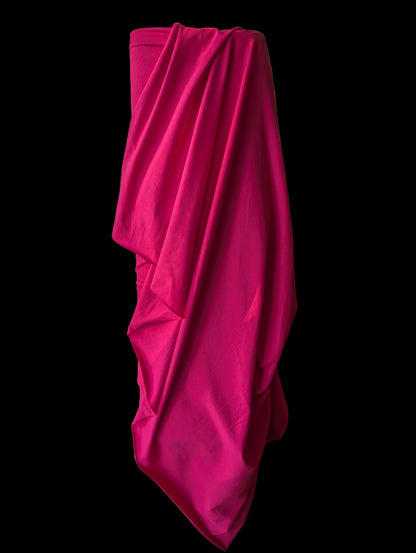Hot pink cotton spandex knit draped over the bolt